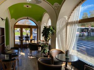 a restaurant with tables and chairs and a window at Penzion Venuša in Spišská Nová Ves