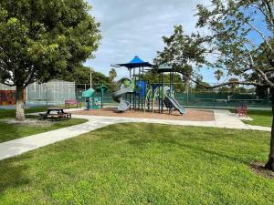 a playground with a slide in a park at Beautiful, quiet & cozy home near Lake Worth Beach in Lake Worth