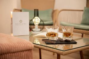 two glasses of whiskey sitting on a glass table at Neocore in Naples +198 photos