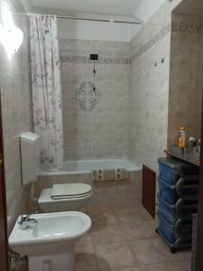 łazienka z toaletą, umywalką i wanną w obiekcie Appartamento nel cuore delle Alpi w Susie