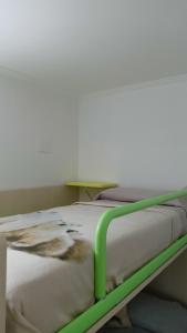 a hospital bed with a green frame in a room at Appartamento nel cuore delle Alpi in Susa