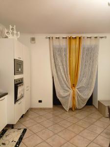 eine Küche mit einem Vorhang in einem Zimmer in der Unterkunft Appartamento nel cuore delle Alpi in Susa