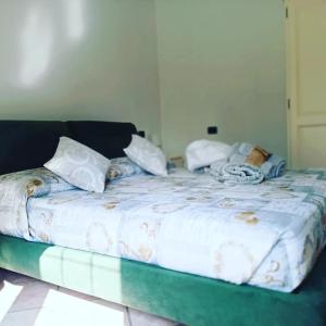 łóżko z białą pościelą i poduszkami w obiekcie Appartamento nel cuore delle Alpi w Susie