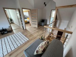 een woonkamer met een bank en een slaapkamer bij Osada Marcowa - Niebieski Domek z sauną & jacuzzi in Zakopane