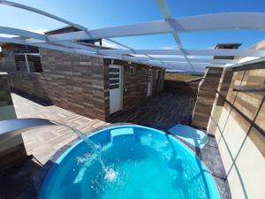 uma piscina com uma pérgola e um pátio com um telhado em Uma agradável morada para descansar em Itapirubá! em Imbituba