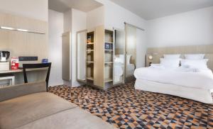 a hotel room with two beds and a couch at Libertel Gare Du Nord Suede in Paris