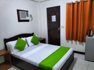 a bedroom with a bed with green pillows and a door at Bans Beach Resort in Boracay