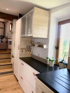 a kitchen with white cabinets and a black counter top at Maisonnette atypique cadarache-iter in Saint-Paul-lez-Durance