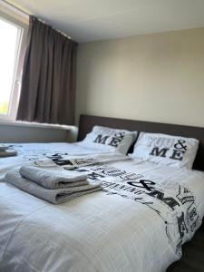 een slaapkamer met een bed met handdoeken erop bij Parnassia in De Koog