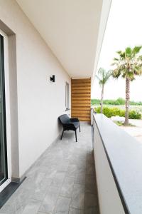 Habitación con silla en el balcón de una casa en Dimora delle Rose Agriresort, en Brusciano