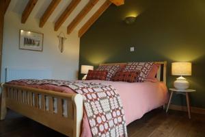 ein Schlafzimmer mit einem Bett und einer grünen Wand in der Unterkunft Tyddyn Plwm Isa in Newborough