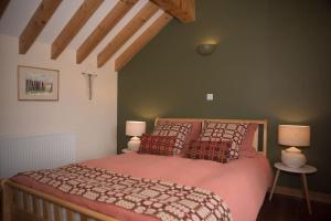 a bedroom with a large bed with two lamps at Tyddyn Plwm Isa in Newborough