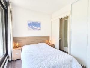 a white bedroom with a bed and two night stands at Appartement Flaine, 4 pièces, 8 personnes - FR-1-425-18 in Flaine