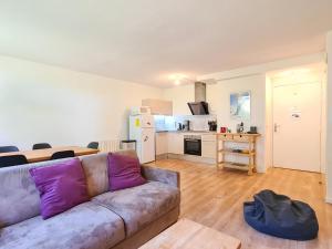 Una sala de estar con un sofá y una cocina. en Appartement moderne 3 pièces à Flaine, capacité 6 personnes - FR-1-425-3, en Flaine