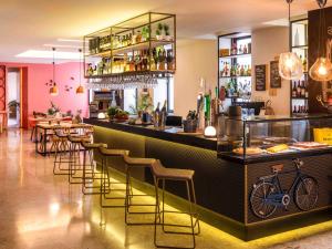 een restaurant met een bar met barkrukken bij Mercure Porto Centro Santa Catarina in Porto