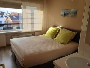 een slaapkamer met een bed, een wastafel en een raam bij 2 bedrooms appartement with city view balcony and wifi at Knokke Heist in Zeebrugge