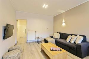 uma sala de estar com um sofá e uma mesa em 2 bedrooms appartement with city view balcony and wifi at Knokke Heist em Zeebrugge
