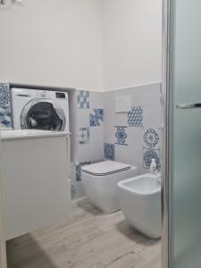 uma casa de banho com uma máquina de lavar roupa e um WC em Lovely Corner em Porto Santo Stefano