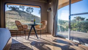 a room with a table and chairs and a large window at Sierra Escape Luxury Glamping in Piambong