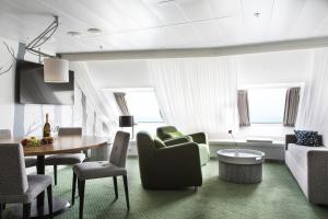 a living room with a couch and a table and chairs at Silja Line ferry - Helsinki to Stockholm in Helsinki