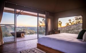 a bedroom with a bed and a view of a deck at Sierra Escape Luxury Glamping in Piambong