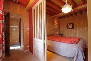 a bedroom with a bed in a wooden house at La Maison De Coco in La Lande-de-Goult