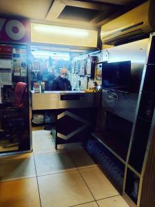 Hotel Novelty في جامو: رجل يجلس في كونتر في مطبخ