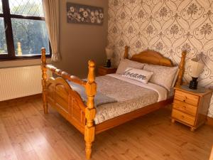 ein Schlafzimmer mit einem Holzbett und einem Fenster in der Unterkunft Davmar House in Cork