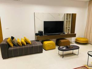 a living room with a couch and a flat screen tv at Sousse Sahloul apartment de luxe 10 min de la mer in Sousse