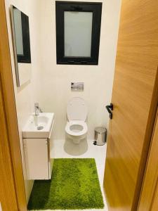 La salle de bains est pourvue de toilettes, d'un lavabo et d'une fenêtre. dans l'établissement Sousse Sahloul apartment de luxe 10 min de la mer, à Sousse