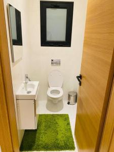 a bathroom with a toilet and a sink and a window at Sousse Sahloul apartment de luxe 10 min de la mer in Sousse