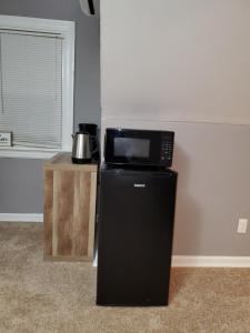 a microwave on top of a refrigerator next to a table at Magnolias in Richmond