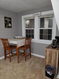 a dining room with a table and two chairs and two windows at Magnolias in Richmond