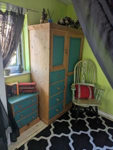 a bedroom with a dresser and a chair and a cabinet at Quiet Quaint & Quirky House Colchester Town Centre in Colchester