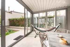 weranda z hamakiem, stołem i krzesłami w obiekcie Renovated APT with Garden & Veranda! w Mediolanie