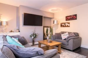 sala de estar con 2 sofás y TV en City Home from Home - Peaceful, Cosy & Modern 2Bed house en Nottingham
