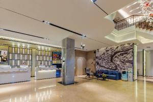 a large room with a lobby with a couch and a table at Echarm Hotel Foshan Guangfo Road Jiaokou Metro Station in Foshan