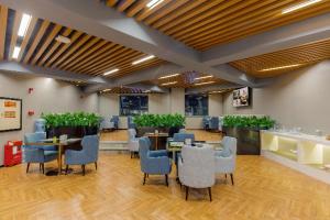 a dining room with tables and chairs and plants at Echarm Hotel Foshan Guangfo Road Jiaokou Metro Station in Foshan