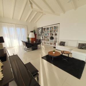 ein weißes Wohnzimmer mit einem Sofa und einem Tisch in der Unterkunft PENTHOUSE Jan Thiel Curacao in Willemstad