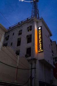a building with a neon sign on the side of it at HOTEL PLAZA GRAND in Jalandhar