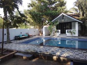 a villa with a swimming pool and a house at God's Gift Morjim in Morjim