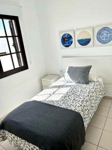 a bedroom with a bed with a black and white blanket at Apartamento La Gaviota in Playa Honda