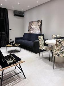 Lagonisi Luxury Apartment by the sea في لاغونيسي: غرفة معيشة مع أريكة وطاولة وكراسي