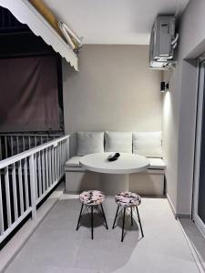 Habitación con mesa y 2 taburetes en el balcón. en Lagonisi Luxury Apartment by the sea en Lagonissi