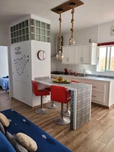 uma cozinha com cadeiras vermelhas e uma bancada em Casa Brisa Marina, en tranquilo pueblo costero. em La Mareta
