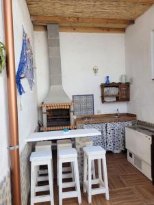 kuchnia z 2 stołkami, stołem i kuchenką w obiekcie Casa Brisa Marina, en tranquilo pueblo costero. w mieście La Mareta