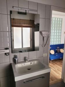 uma casa de banho com um lavatório e um espelho em Casa Brisa Marina, en tranquilo pueblo costero. em La Mareta
