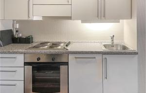uma cozinha com armários brancos, um fogão e um lavatório em Amazing Apartment In Lillehammer With Sauna em Lillehammer