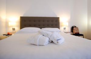 2 asciugamani sono impilati sopra un letto di Mistral2 Hotel a Oristano