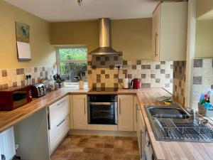 a kitchen with a sink and a stove at Bluebell Cottage in the Yorkshire Dales in Stainforth